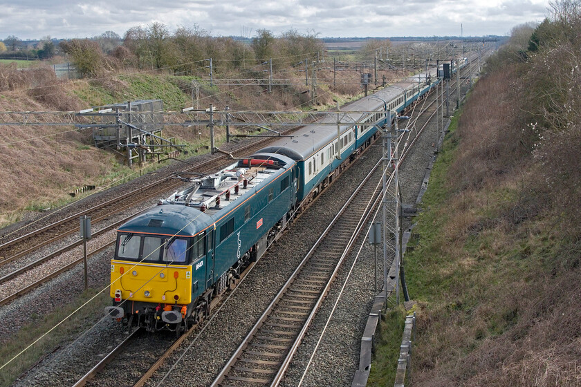 86401, 09.24 Liverpool South Parkway-Wembley Central (1Z86, 62L), Victoria bridge 
 Still wearing its Caledonian Sleeper livery and branding 86401 'Mons Meg' brings up the rear of the 1Z86 09.24 Liverpool South Parkway to Wembley Central footex. Running over an hour late due to issues before the train had even left Merseyside it has made up some time being one hundred minutes late on arrival at Rugby. Signallers eventually found a slot on the up fast line thus avoiding the Northampton loop but this did come at the expense of holding up a number of Pendolinos. The train is seen passing Victoria bridge near Roade with 86259 ' Les Ross/Peter Pan' leading. The Liverpool supporters will all have been able to make the match and would have returned happily after their team beat Chelsea 1-0 in the one hundred and eighteenth minute of extra time. 
 Keywords: 86401 09.24 Liverpool South Parkway-Wembley Central 1Z86 Victoria bridge Mons Meg