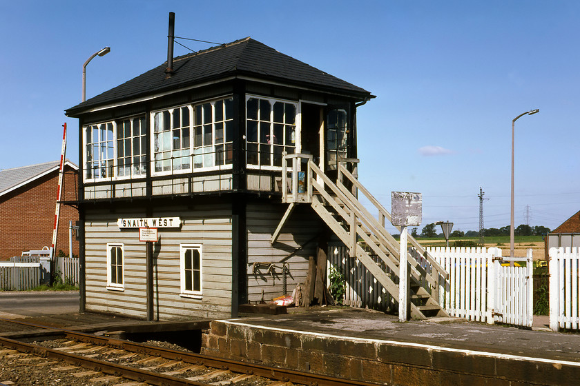 Snaith West signal box (Mid, date not known) 
 In the early morning sunshine, Snaith West signal box is seen standing at the western end of the small station next to the level crossing. The box is unmistakably Midland in origin but its date of construction alludes me and the great worldwide web alike - unless anybody can elighten me! In the next couple of years or so after this photgraph was taken, the line from Drax Branch Junction to Goole was singled by BR with the track seen here lifted and the platform removed an arrangement that remains today. 
 Keywords: Snaith West signal box Midland