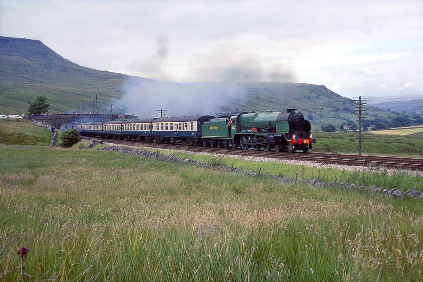 850, outward leg of The Cumbrian Mountain Express, Carlisle-Skipton, Ais Gill Summit SD775967 
 With the bulk of Wild Boar Fell in the background SR 850 'Lord Nelson' approaches Ais Gill leading the outward leg of The Cumbrian Mountain Express from Carlisle to Skipton. After battling the eighteen miles or so of almost continuous 1:100 from Appleby 850 is still going well as it approaches the summit at nearly one thousand one hundred and sixty-nine feet, making it the highest point on the S & C. It is not evident in this photograph but there were hundreds of photographers in an ark either side of me at this popular spot many of whom dashed to their cars after the train had passed with the same idea as us, to get ahead of the train again as it had a water stop at Garsdale station!

There is an audio recording of this event on my youtube channel, see...https://youtu.be/0CmKCG9W2J0 
 Keywords: 850 outward leg of Cumbrian Mountain Express Carlisle-Skipton Ais Gill Summit SD775967 850 Lord nelson Maunsell