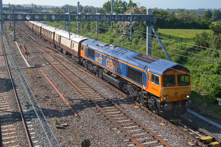 66737, 06.49 London Victoria-Kidderminster SVR (1Z60, 2L), Sharnbrook TL001598 
 Every minute that this charter was delayed, and by this stage this was mounting up, meant that the photograph was becoming even more backlit! 66737 'Lesia' leads the outward leg of a VSOE private charter organised by GBRf who supplied their own motive power. The charter left Victoria at 06.49 running as 1Z6o picking up as far as Kettering heading for the Severn Valley Railway. Out of sight on the rear here at Shernbrook Junction was 50049 'Defiance'. I have photographed many trains at this location but this is the first one since the installation of the electrification, by way of comparison, this is what it used to look like..... https://www.ontheupfast.com/p/21936chg/24224339404/x222001-1d09-sharnbrook-junction 
 Keywords: 66737 06.49 London Victoria-Kidderminster SVR 1Z60 Sharnbrook TL001598 Lesia Defiance 50049