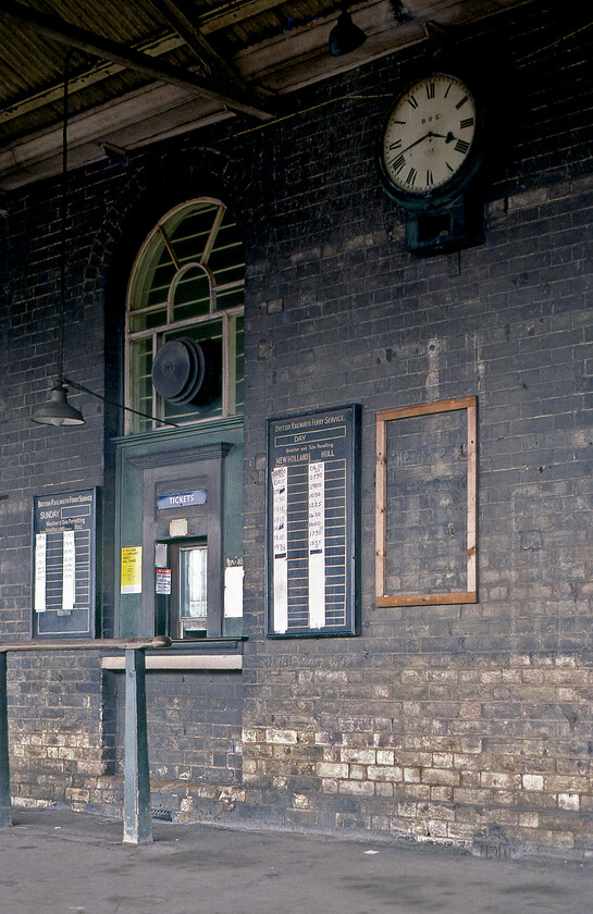 Ticket office, New Holland Town station 
 The ticket window at New Holland Town station displays a fine collection of period features from the Eastern Region enamel to the wooden boards with pasted on self-prepared ferry timetables. Notice also the lovely downlighter lamp that extends over where the customer would stand to purchase their tickets. I must have been quite taken with this part of New Holland Town station as I took another photgraph using black and white film, see.....https://www.ontheupfast.com/p/21936chg/30026575197/x37-ticket-office-new-holland-town 
 Keywords: Ticket office New Holland Town station