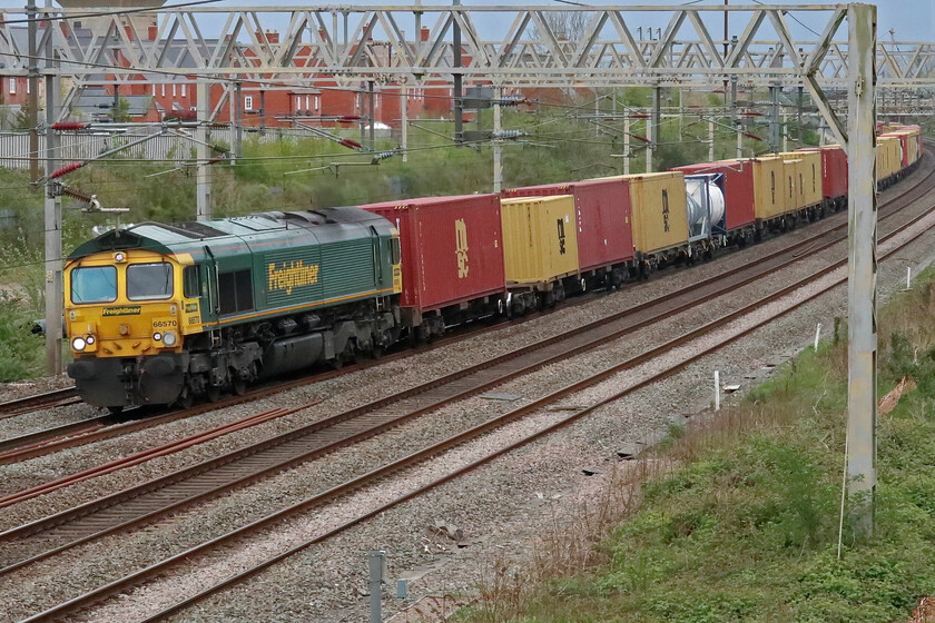 66570, 12.57 London Gateway-Garston (4M56, 34E), site of Roade station 
 Freightliner's 66570 leads the 12.57 London Gateway to Garston intermodal service past the site of Roade's former station. After a relatively bright day, the late afternoon has become dull with a thick veil of grey cloud acting as a portent to yet more rain! 
 Keywords: 66570 12.57 London Gateway-Garston 4M56 site of Roade station Freightliner