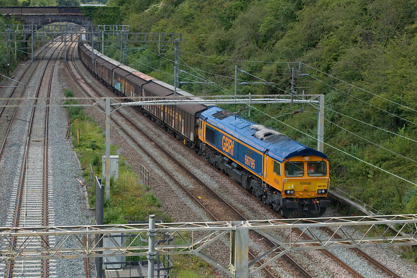 66795, 14.40 DIRFT-Dollands Moor (6O55, 12L), A508 bridge 
 More used to seeing a dirty and unkempt DB red Class 66, often still in its redundant EWS livery, on the Daventry to Dollands Moor (and the incoming service) water train the sight of a smart GBRf example is a real contrast especially when looking at the stock! 66795 'Bescot LDC' leads the 6O55 empty cargo waggons back to Dollands Moor that will then continue their journey back through the tunnel to the continent. I was also pleased to capture this particular 66 as it was a photographic cop! 
 Keywords: Bescot LDC 66795 14.40 DIRFT-Dollands Moor 6O55 A508 bridge GBRf water train