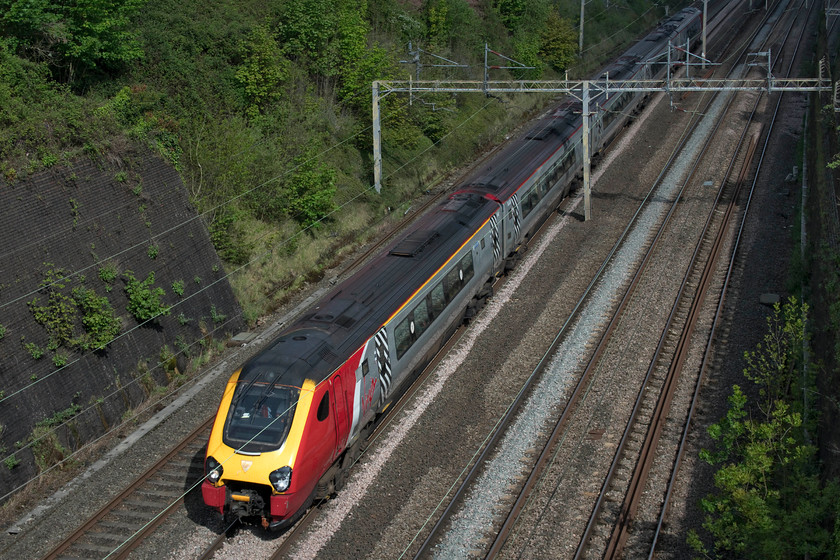 Class 221, VT 06.52 Holyhead-London Euston (1A15, 1E), Roade cutting 
 An unidentified class 221 speeds through Roade cutting with the 06.52 Holyhead to Euston. Whilst the front of the Virgin working is in sunshine, the rear is in shadow such was the changeable nature of the weather. 
 Keywords: Class 221 VT 06.52 Holyhead-London Euston 1A15 Roade cutting