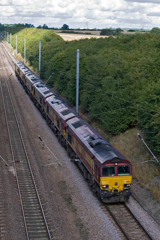 66184 & Class 66, 06.48 Immingham Maintenance Shed-Whitemore Yard (0X14), Westby SK 962271 
 66184 leads five classmates as the 0X14 Immingham to March Whitemoor light engine move. Unfortunately, I have not managed to capture the rest of the locomotive numbers and they had just dropped into some shadow as the descend Stoke Bank near the village of Westby on the up slow line. They will diverge from the ECML at Peterborough to head on the final leg to March. 
 Keywords: 66184 Class 66 06.48 Immingham Maintenance Shed-Whitemore Yard 0X14 Westby SK962271 EWS