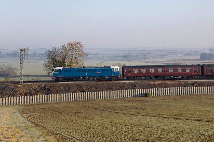 86259, outward leg of The Winter Cumbrian Mountain Express, 07.09 London Euston-Carlisle (1Z86), Blisworth 
 I retrospect I did not really quite get the positioning of 86259 'Les Ross/Peter Pan' quite right with a tree growing out of its roof! Last-minute I decided to ramp the shutter speed up instead of trying a pan shot as I decided that I was too far away for that. Wrong decision, I should have tracked the locomotive in the viewfinder, cropped it down and said tree would have been far less obtrusive! The Class 86 is leading the outward leg of The Winter Cumbrian Mountain Express past Blisworth just north of Roade cutting. It was removed at Carnforth for Black 5 46115 'Scots Guardsman' taking over for the run over Shap to Carlisle and then to return south via the Settle and Carlisle route to Farrington Junction. 
 Keywords: 86259 The Winter Cumbrian Mountain Express 07.09 London Euston-Carlisle 1Z86 Blisworth Les Ross Peter Pan AC electric AL6