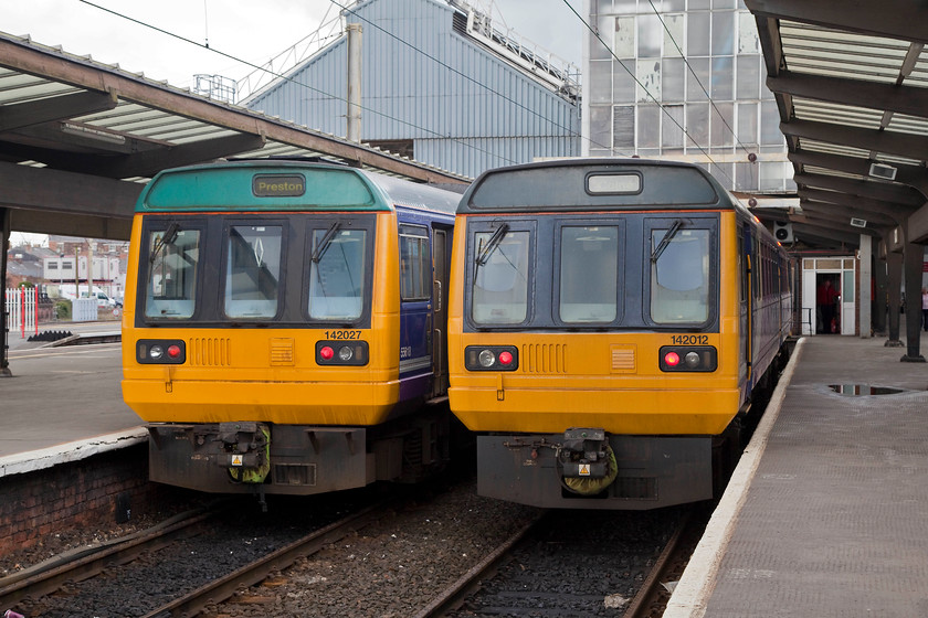 142027 & 142012, stabled, Preston station 
 Living on borrowed time, 142027 and 142012 sit side by side in Preston's bay platforms waiting to perform their next duty. Much maligned and disliked by many, they have forged their own place in the history of railways in the UK. None have been preserved yet, but I expect a number will end up on on the many heritage lines around the country. 
 Keywords: 142027 142012 stabled Preston station