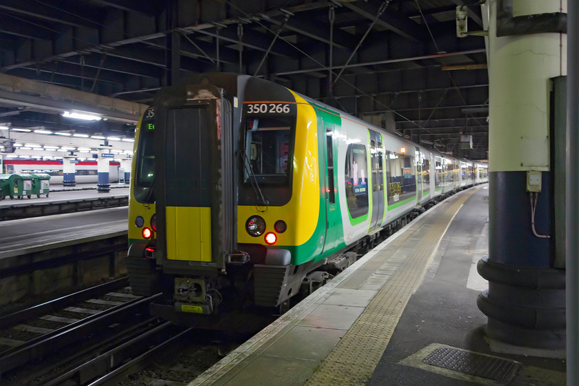 350266, LM 22.24 London Euston-Northampton (2N31, 1E), London Euston station 
 Our train home to Northampton sits in the gloom at London Euston. As the concert finished late, we were forced to leave early to catch the 22.24 Euston to Northampton, unfortunately, a stopper that took an earth to get us home! 
 Keywords: 350266 22.24 London Euston-Northampton 2N31 London Euston station