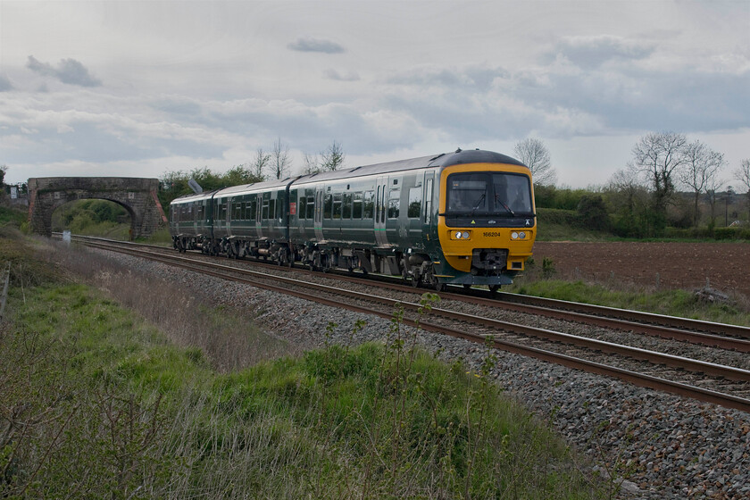 166204, GW 14.55 Weymouth-Gloucester (2V72, 8L), Fairwood ST851513 
 Having left the mainline at Fairwood Junction about a third of a mile beyond the bridge 166204 'Norman Topson MBE' heads towards Westbury station working the 14.55 Weymouth to Gloucester GWR service. This very smartly repainted unit is adorned with a large vinyl imitation nameplate that commemorates the work of the long-serving railwayman that worked at Twyford station. Known as 'Mr Twyford' he retired in November 2015 after 53 years of service on the railways. 
 Keywords: 166204 14.55 Weymouth-Gloucester 2V72 Fairwood ST851513 Great Western Railway GWR Turbo 'Norman Topson MBE'