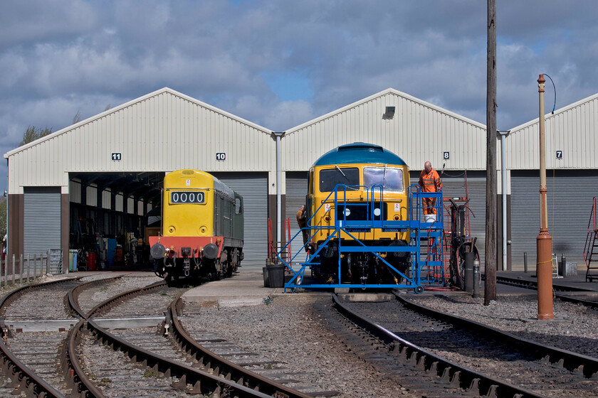 D8137 & 47105, stabled, Toddington Yard 
 Work is undertaken on 47105 in the spring sunshine outside the Gloucestershire and Warwickshire Railway's impressive and large eleven road shed. This Class 47 was a regular performer in the West Country in the 1970s and 1980s. Next to the Brush Type 4 is D8137 (20137) that is a permanent resident on the line and has been in almost continual operation since its rebuild that was completed in 1995. 
 Keywords: D8137 47105 Toddington Yard Gloucestershire and Warwickshire Railway