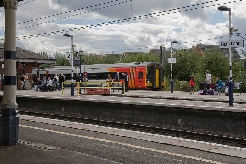 158783, EM 11.57 Norwich-Liverpool Lime Street (1R86), Grantham station 
 A busy scene at Grantham with passengers waiting for a Nottingham to Skegness train that is due whilst another East Midlands Trains service stands at platform four. 158783 is working the 11.57 Norwich to Liverpool train. Is a two-car DMU really enough for such an inter-regional service such as this? 
 Keywords: 158783 11.57 Norwich-Liverpool Lime Street 1R86 Grantham station East Midlands Trains