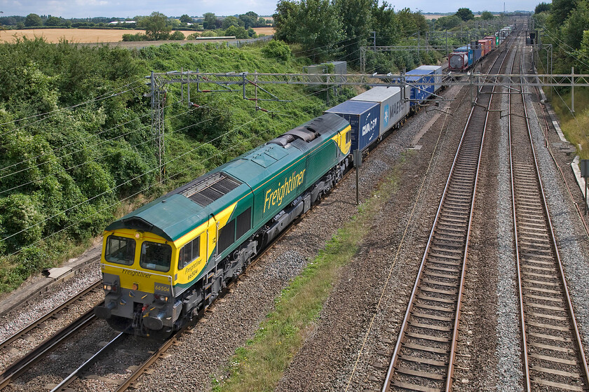 66504, 09.32 Felixstowe North-Crewe Basford Hall (4M88), Victoria bridge 
 In some welcome warm summer sunshine 66504 passes Victoria bridge just south of Roade leading the 09.32 Felixstowe to Basford Hall Freightliner. I think that this version of Freightliner's livery that was applied last year looks very smart and keeps the Class 66s looking good despite that this particular example is now fifteen years old. Just think what a state some of the first generation BR diesels were in back in the early 1980s that were then the same age. 
 Keywords: 66504 09.32 Felixstowe North-Crewe Basford Hall 4M88 Victoria bridge