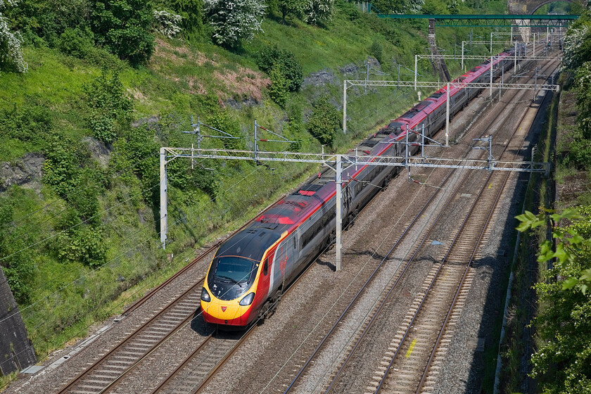 Class 390, VT 06.30 Glasgow Central-London Euston, Roade cutting 
 An unidentified Class 390 Pendolino passes south through Roade cutting working Virgin's 06.30 Glasgow Central to Euston service. It makes a welcome change to present a photograph taken in the sunshine as so far this spring we have not seen very much of it and tomorrow is the first day of meteorological summer! 
 Keywords: Class 390 06.30 Glasgow Central-London Euston Roade cutting Virgin Pendolino