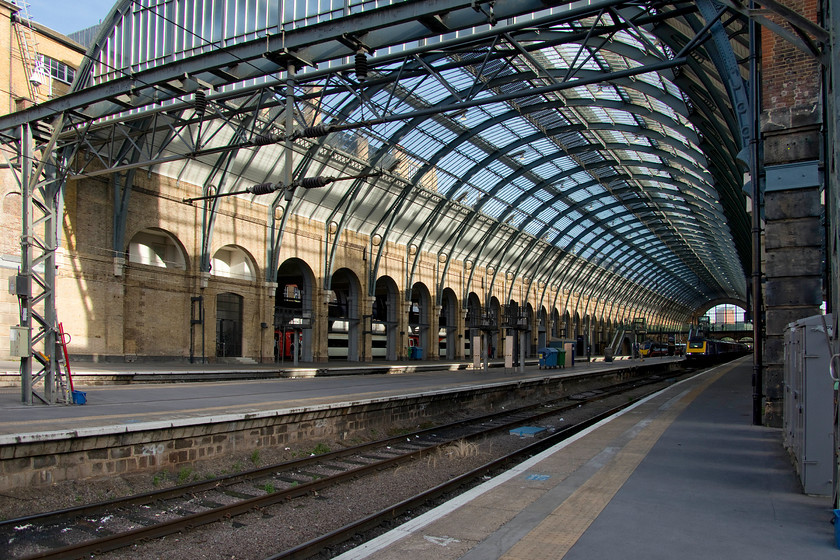 Trainshed, 43023, HT 18.48 London King`s-Cross Hull (1H06, 7L), London King`s Cross station 
 As I was sitting on my stool on the platform at King's Cross, I looked back to the trainshed and was struck by the majesty of the structure with the summer sun streaming through the recently cleaned and renovated glazing. Inside the structure, an HST will soon depart as the 18.48 to Hull and a class 180 that would leave over half an hour late for Sunderland keeping the very hot and uncomfortable passengers waiting outside the train on the platform probably not appreciating the majesty of the structure as much as I was! 
 Keywords: Trainshed 43023 18.48 London King`s-Cross Hull 1H06 London King`s Cross station