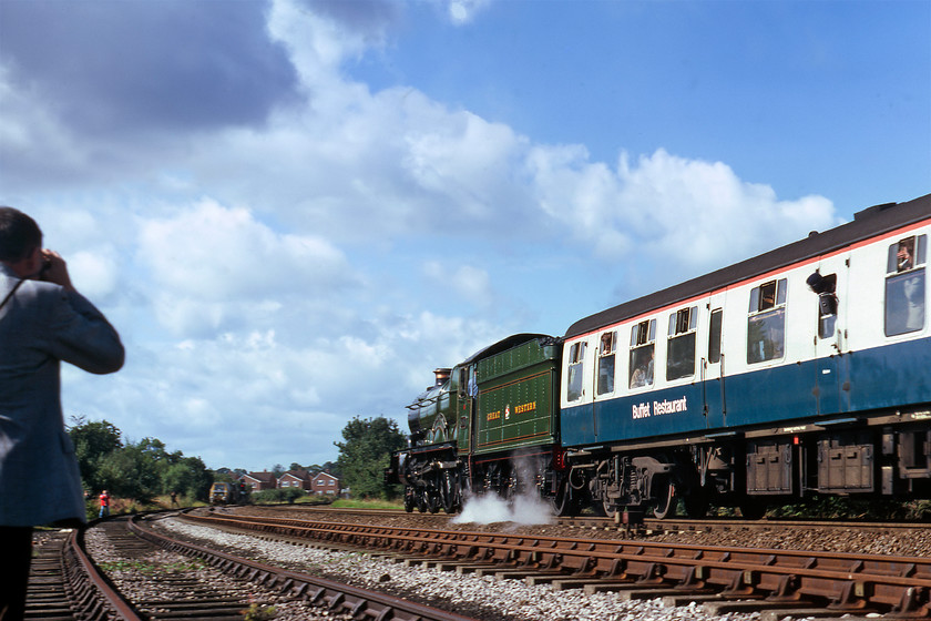 5051, outward leg of The John Mynors Memorial, London Paddington-Bridgnorth (SVR), Hatton Bank SP226663 
 This is my version of the previous one! Graham passed his transparency on to me as a reject but whilst my version has less motion blur its composition is not so good! It shows 5051 Drysllwyn Castle storming up Hatton bank approaching the station that is just level with the houses in the distance. Notice the balaclava and goggle-wearing enthusiast leaning from the droplight holding what appears top be a radio/cassette recorder out of the window. Without some protection to the microphone, I feel that the recording would suffer from the scourge of wind noise! Also, notice the Plasser and Theurer track machine stabled in the siding further around the curve. 
 Keywords: 5051 The John Mynors Memorial London Paddington-Bridgnorth SVR Hatton Bank SP226663