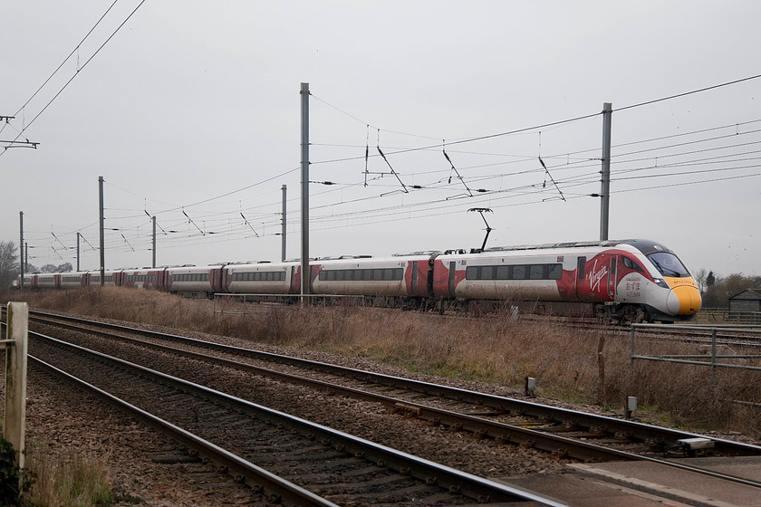 800101, 08.55 Doncaster Carr-Peterborough (5X60), Woodcroft Crossing TF139050 
 This was my first view of an IEP Azuma on the ECML and branded in Virgin EC livery. here, 800101 passes Woodcroft Crossing on the up fast working the 08.55 Doncaster Carr to Peterborough test train running as 5X60. This is a suitably long nine-car formation but I suspect that the seating and general environment will not be as good as in the excellent MkIVs that they are replacing. 
 Keywords: 800101 5X60 Woodcroft Crossing TF139050