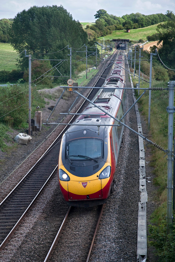 390137, VT 14.40 London Euston-Manchester Piccadilly (1H69, RT), Weedon SP635589 
 390137 'Virgin Difference' is seen working the 14.40 Euston to Manchester Piccadilly on the approach to Weedon. In the background, Stowehill Tunnel can be seen with the sun also shining at the far end of it. The 491 yard tunnel was completed in 1838 by The London and Birmingham Railway. 
 Keywords: 390137 1H69 Weedon SP635589