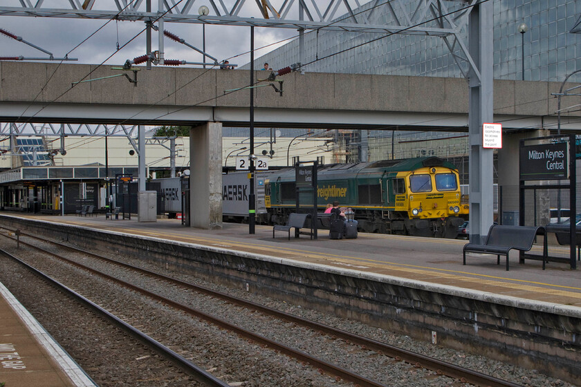 66569, 10.08 Lawley Street-Felixstowe North (4L93), Milton Keynes Central station 
 The passage of freight workings through Milton Keynes is always a dramatic moment as they are running a fair old rate and anybody standing on the narrow platforms complete with their baggage can be somewhat exposed as the boxes pass with the consequential and substantial drafting. 66569 is doing just that as it passes through platform one leading the 4L93 10.08 Lawley Street to Felixstowe Freightliner service. 
 Keywords: 66569 10.08 Lawley Street-Felixstowe North 4L93 Milton Keynes Central station