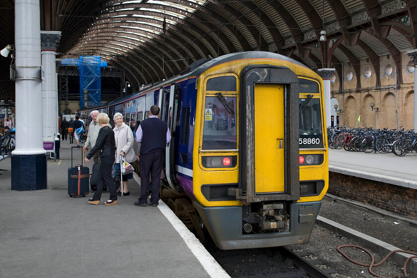 158860, NT 11.40 Selby-York (2R88), York station 
 158860 has just terminated at York's platform one with the 11.40 from Selby. The Northern guard is seen assisting customers departing from the train and is obviously exchanging some amusing words with them! Notice the huge numbers of bikes to the right of the photograph. There is active consideration being given to reinstating the second bay platform to improve capacity; will this become another of the fabled platform zeros? 
 Keywords: 158860 11.40 Selby-York 2R88 York station Northern