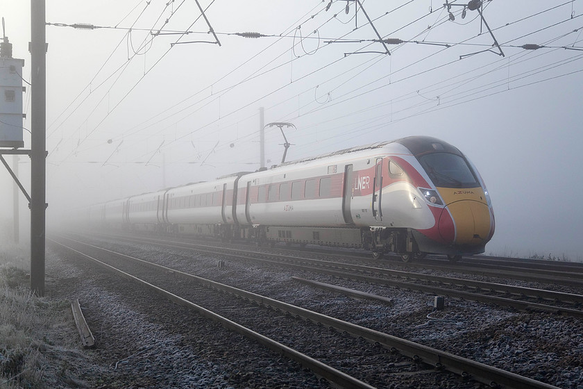 800110, VT 08.33 London King`s Cross-Leeds (1D06, 6L), Holme Green Crossing TL192426 
 I have said it before, but the livery applied by LNER to the Azuma fleet is so much better than that applied by GWR to their fleet. Here in the thick fog at Holme Green crossing just south of Biggleswade 800110 heads north working the 1D06 08.33 King's Cross to Leeds. I have visited this spot a number of times, the last time was in mid-summer when the scene was very different, see..... https://www.ontheupfast.com/v/photos/21936chg/24908407404/x91131-1b92-holme-green-crossing and, look those same two lengths of discarded rail are still there two years later! 
 Keywords: 800110 08.33 London King`s Cross-Leeds 1D06 Holme Green Crossing TL192426 Azuma Virgin Trains East Coast