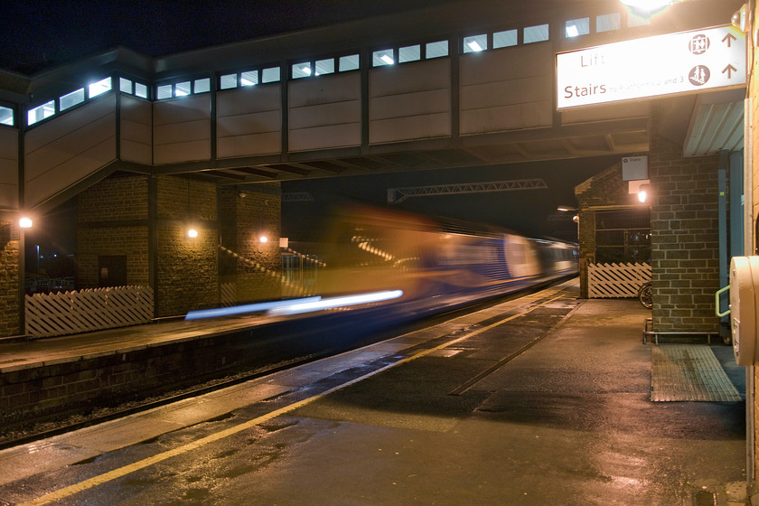 Class 43, EM 18.19 London St. Pancras-Sheffield (1F63, 7L), Wellingborough station 
 I enjoy the opportunities afforded by nighttime photography. The quality of light is totally different, with everyday scenes taking on completely different atmospheres. In the case of this image, I have embraced something that, in normal railway photography, we avoid at all costs, motion blur. By using a long shutter speed of 1/5th of a second, the HST passing through Wellingborough station takes on an almost ethereal appearance. It is forming the 18.19 London St. Pancras to Sheffield. However, photographs such as this require need some work in Photoshop with a relatively new problem shown up in this image. The light temperatures of traditional lighting and the more modern low energy units create areas of yellow 'warmth' verses the 'cool' blueish/white of light-emitting diodes. 
 Keywords: Class 43 HST 18.19 London St. Pancras-Sheffield 1F63 Wellingborough station