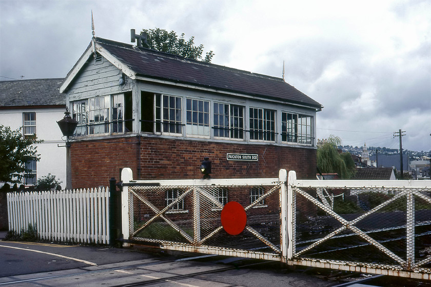 Paignton South signal box (GW, date not known) 
 Paignton south signal box is seen with its associated crossing gates. I believe that the box is GWR Type 3 but have no details of its construction date. However, as it has the higher roof with steeper pitch would suggest its the earlier design pre 1895ish. Notice the huge lamp above the railway picket fencing. In a slightly later photograph from 1982, the lamp had disappeared with the box being closed in 1985. Today the crossing still exists but is controlled by automatic barriers with a revolting and characterless relay room replacing the delightful GWR building. 
 Keywords: Paignton South signal box