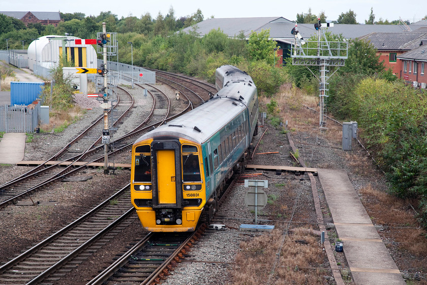 158831, AW 12.09 Birmingham International-Aberystwyth & Pwllheli (1J15 & 2J15), Sutton Bridge Junction 
 ATW's 158831 has been signalled by Sutton Bridge Junction signal box to take the Welshpool line on the bracket to the right of the train. It is just passing over the first set of points that takes it momentarily on to the down fast for it then head away from the Marches line to the west. The signal post to the left has a smaller horizontally striped subsidiary arm below the distant. This is necessary to give a driver special information about the section ahead. When off, a letter C (calling on), S (Shunt ahead) or W (Warning ahead-proceed with caution) will be displayed. 
 Keywords: 158831 12.09 Birmingham International-Aberystwyth Pwllheli 1J15 2J15 Sutton Bridge Junction