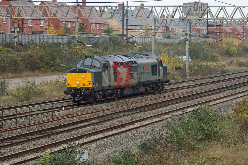 37884, 10.37 Old Oak Depot-Derby RTC (0M57, 32E), site of Roade station 
 The 10.37 Old Oak Common Depot to Derby RTS 0M57 light engine move passes Roade worked by 37884 'Cepheus'. There seems to be a lot of these light engine moves at the moment as various stock is moved around the country. I always wonder why these trains travel on the WCML as far as Nuneaton where they reverse to get to Leicester via Narborough rather than take the Marston Vale line from Bletchley to Bedford to then take the MML to Derby. 
 Keywords: 37884 10.37 Old Oak Depot-Derby RTC 0M57 site of Roade station Rail Operations Group ROG Cepheus