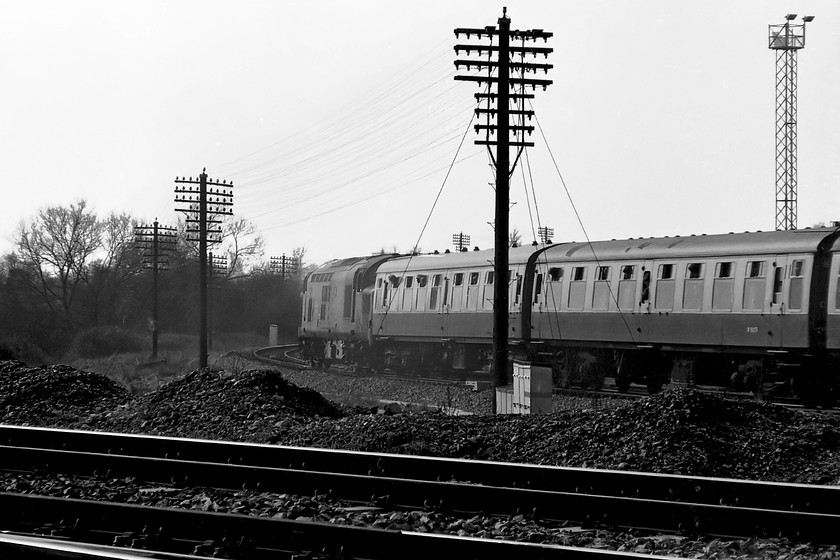 37233, outward leg of The Pines Express, 07.48 London Paddington-Weymouth (via Bristol & various freight lines), Westbury South 
 Yet another going-away shot of 37233 as it takes The Pines Express away from Westbury past the south junction. I like this picture with the telegraph wires silhouetted against the afternoon sky. I am in an 'unofficial' spot here at Westbury South but one that I visited a number of times but never had any bother from railway staff. As the train was so late, I had now to rush home in order to complete my afternoon paper round delivering the Bath Evening Chronicle but not without a quick visit to Westbury depot first! 
 Keywords: 37233 The Pines Express 07.48 London Paddington-Weymouth Westbury South