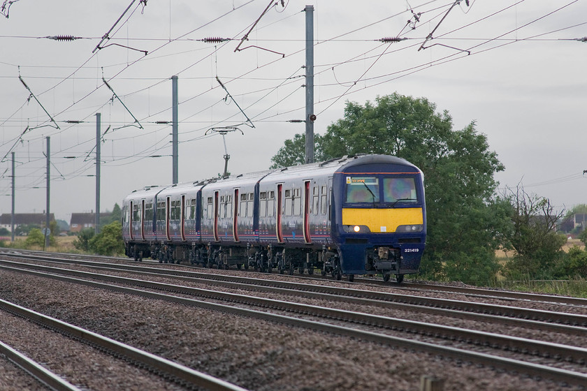 321419, GN 07.35 London King`s Cross-Peterborough (2P04), Holme Green crossing TL192426 
 Great Northern's 321419 looks somewhat dwarfed by the electrification paraphernalia as it heads along the ECML past Holme Green crossing located a short distance south of Biggleswade. The unit is working the 07.35 King's Cross to Peterborough stopper on the down slow line. In a previous life, this was a unit was one that I saw frequently in its distinctive Silverlink livery on the WCML between Birmingham and Euston. 
 Keywords: 321419 07.35 London King`s Cross-Peterborough 2P04 Holme Green crossing TL192426