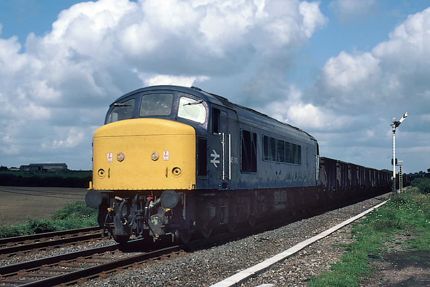 45010, up freight, Irchester SP930663 (Courtesy of GGV) 
 45010 leads a long unfitted freight mainly composed of what appears to be rake of sixteen-ton mineral wagons past the site of Irchester's closed station taken from the former goods yard. The distant signal is controlled by Irchester South signal box some distance from this location thus would be motorised, hence the absence of trackside signalling wires. The Peak would remain in service for another five years being withdrawn in March 1985 and eventually being cut up at Springburn (Glasgow) by January 1989. 
 Keywords: 45010 up freight Irchester SP930663