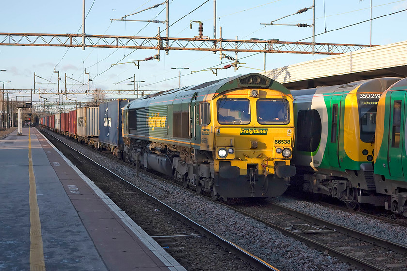 66538, 12.32 Crewe Basford Hall-Felixstowe (4L90) & 350259, LN 14.54 Birmingham New Street-London Euston (2Y14, 2L), Northampton station 
 On arrival back at Northampton station, I was pleased to see 66528 making its way slowly along the centre road preparing to stop for a red light. The heavily loaded Freightliner was the 12.32 Crewe Basford Hall to Felixstowe North working. It was stopping to allow the London Northwestern 14.54 Birmingham New Street to London Euston working, seen on the right, to leave first. 
 Keywords: 66538 12.32 Crewe Basford Hall-Felixstowe 4L90 350259 2Y14Northampton station