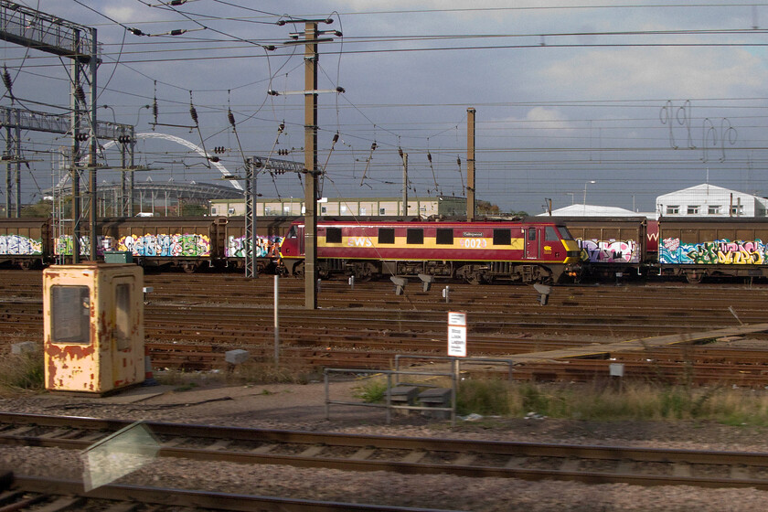 90020, stabled, Wembley Yard 
 90020 'Collingwood' is seen in the afternoon sunshine stabled in Wembley yard as we pass on our journey north. Notice the heavily graffitied Cargo Waggons (sic) behind the Class 90 that will be forming either the up or down bottled water train that runs between the continent and Daventry using the tunnel. 
 Keywords: 90020 Wembley Yard Collingwood