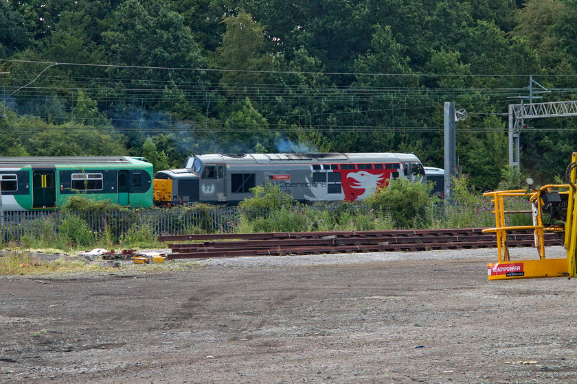 37884 & 455845, 08.54 Wolverton Centre Sidings-Stewarts Lane (5O88), Wolverton Centre Sidings 
 As I was riding my bike along Mcconnell Drive from Wolverton to Milton Keynes I glanced across to the WCML and saw this scene! 37884 'Cepheus' leaves Wolverton's Centre Sidings leading 455845 back to Stewarts Lane. The class 455 had been receiving attention at Wolverton and was returning to the Southern to resume its duties. 
 Keywords: 37884 455845, 08.54 Wolverton Centre Sidings to Stewarts Lane 5O88 Wolverton Centre Sidings