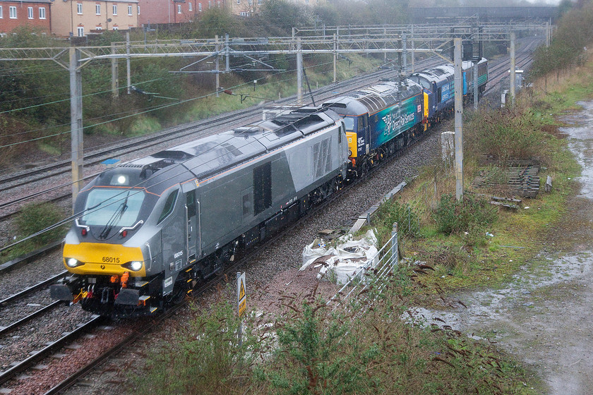 68015, 57307 & 37405, 07.23 Crewe Coal Sidings-Willesden (5A68), site of Roade station 
 In absolutely foul and cold weather a convoy composed of 68015, 57307 'Lady Penelope', 37405 and a Mk.II DRS coach pass the site of Roade station as the 07.23 Crewe Coal Sidings to Willesden 5A68 move. I never actually discovered what this eclectic set of locomotives were making the move for? Either way, I was mightily pleased to get home and warm up! 
 Keywords: 68015 57307 37405 07.23 Crewe Coal Sidings-Willesden 5A68 site of Roade station