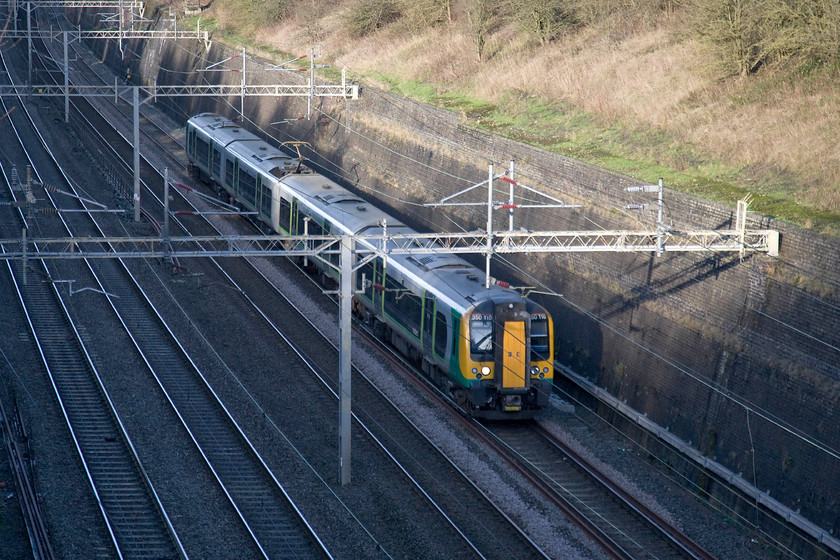 350116, LM 11.33 Birmingham New Street-London Euston (1W12), Roade cutting 
 No doubt carrying revellers heading for the capital for the night's New Year celebrations 350116 passes south through Roade cutting. The Desiro is working London Midland's 1W12 11.33 Birmingham to Euston service. Given the expected numbers travelling to London, I am surprised that an extra set was not attached to this service. 
 Keywords: 350116 LM 11.33 Birmingham New Street-London Euston 1W12 Roade cutting London Midland Desiro