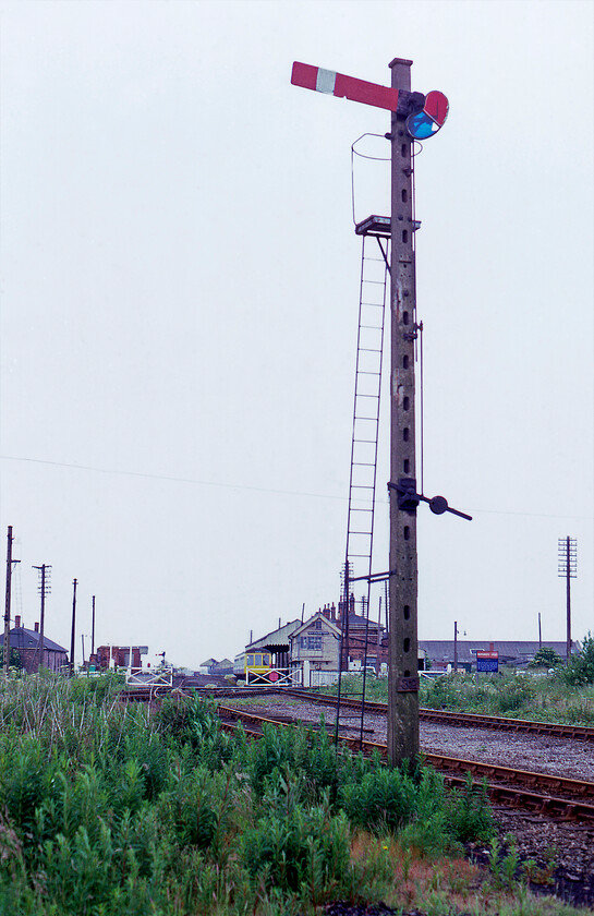 Signalling, New Holland Town 
 A lovely concrete signal post is seen at New Holland Town. I recall from this visit in 1981 how ancient the railway infrastructure felt in this North Lincolnshire bywater. There was also an air of general decay compounded by the imminent closure of the railway that is seen in this image running along the pier connecting with the Humber Ferry. This closure was precipitated by the opening of the Humber bridge that would take place less than a week after this photograph was taken. 
 Keywords: Signalling New Holland Town