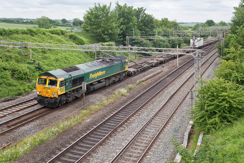 66568, 09.25 Southampton-Garston FLT (4M28), Victoria Bridge 
 Under ledden skies 66568 heads north past Victoria Bridge just north of Hanslope Junction with the 4M28 09.25 Southampton to Garston Freightliner. Looking at the wagons behind the loco. there appears to be a lot of fresh air being carried along and not a lot of fright! 
 Keywords: 66568 09.25 Southampton-Garston FLT 4M28 Victoria Bridge