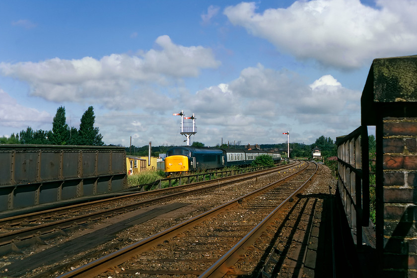 45117, 09.01 Nottingham-London St. Pancras (1C23), Sharnbrook TL005592 
 Graham and I scrambled up the embankment from road level in Sharnbrook to secure this photograph of 45117 heading south with the 09.01 Nottingham to St. Pancras service. I am standing rather too close to the up slow line with Sharnbrook signal box seen in the distance with some of its associated signals. The bracket signal with its submissive home controls the crossover between the fast and slow lines referred to as Sharnbrook Junction that still is in use today. 
 Keywords: 45117 09.01 Nottingham-London St. Pancras Sharnbrook TL005592 Peak 1C23