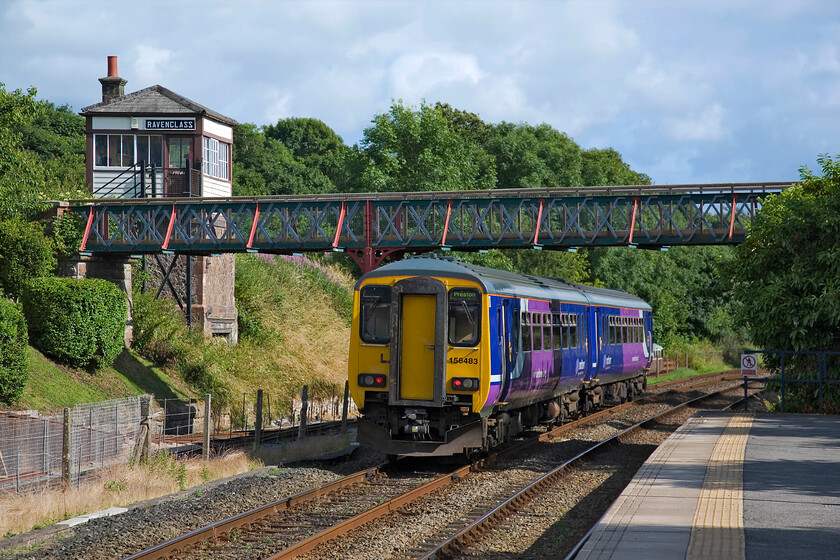 156483, NT 15.12 Carlisle-Preston, Ravenglass station 
 156483 leaves Ravenglass station working the 15.12 Carlisle to Preston service. It is about to pass under an attractive footbridge that visitors to the Ravenglass and Eskdale Railway use. The footbridge is one of the reasons that the 1874 Furness signal box was built so tall in order to offer better sighting for the signalmen. The box was closed by BR in 1965 and is now occasionally open to visitors to the Ravenglass & Eskdale Railway. 
 Keywords: 156483 15.12 Carlisle-Preston Ravenglass station Northern