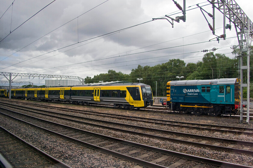 777004 & 08868, stabled, Crewe LNWR 
 Crewe's LNWR facility has become synonymous with the storage of new units awaiting delivery to their operators. Merseyrail's much-heralded replacement of their ageing Class 507/508 units is heavily delayed due to testing and delivery issues with units waiting to enter service held at Crewe. 777004 is seen in its 'beesting' livery but currently unbranded with 08868 protecting the front end of the unit. 
 Keywords: 777004 08868 stabled Crewe LNWR Merseyrail