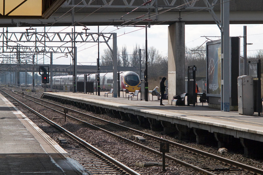 390008, VT 09.43 London Euston-Glasgow Central (9S55), Milton Keynes Central station 
 A passengers wait in the early spring sunshine 390008 'Virgin King' passes Milton Keynes station at speed with the 09.43 Euston to Glasgow Central. 
 Keywords: 390008 09.43 London Euston-Glasgow Central 9S55 Milton Keynes Central station