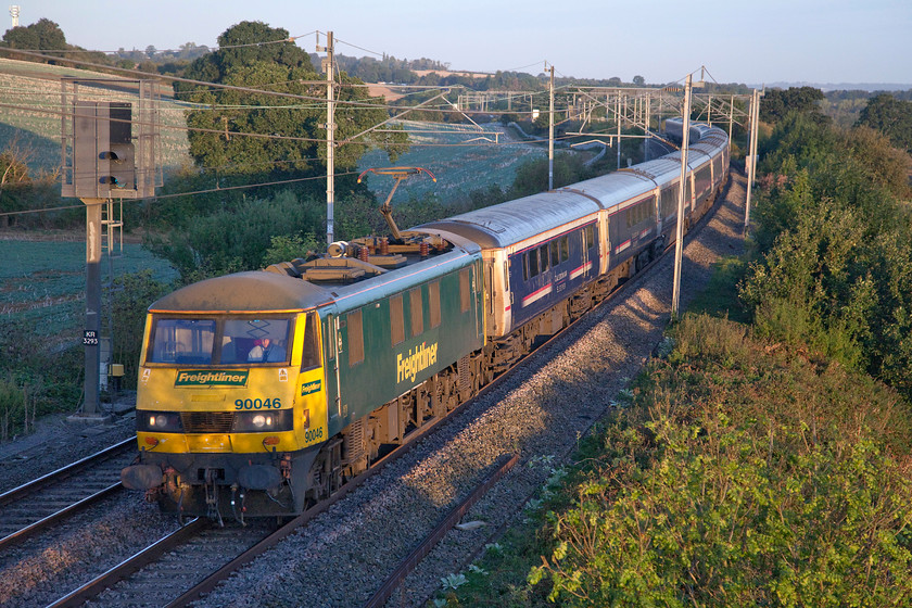 90046, CS 19.50 Fort William, 21.43 Aberdeen, 20.45 Inverness-London Euston (1M16, 1E), Milton crossing 
 With the sun just high enough up to illuminate the train, 90046 leads the Highland sleeper past Milton Crossing on the Weedon loop just north of Roade. The 19.50 Fort William/21.43 Aberdeen and 21.45 Inverness to Euston service is STILL composed of Mk. IIIs, now the best part of ten months after it should have been replaced by the CAF Mk. V stock. With various problems still plaguing the Lowland sleeper, that moved over to the new stock in May, there is still no date given as to when time will be called on this veteran 1980s stock 
 Keywords: 90046 19.50 Fort William 21.43 Aberdeen 20.45 Inverness-London Euston 1M16 Milton crossing