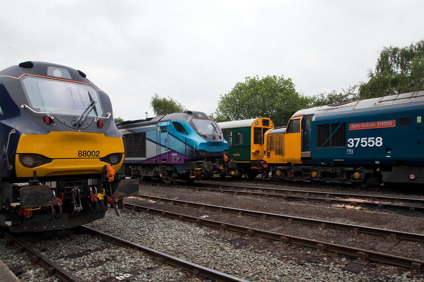 88002, 68021, 975025 & 37424 (37558), on-display, DRS Open Day, Gresty Bridge. 
 88002 'Prometheus' stands next to a very similar looking (apart from in livery) 68021'Tireless'. The class 68 is in its TransPennine Express vinyls and no yellow ends as it is exempt due to its new headlight configuration. Behind the 68 is observation saloon 975025 'Caroline' and then 37558 displaying proudly its 'Avro Vulcan XH558' nameplate. the 37 is actually 37424 masquerading as a 37 '5' in order to match the nameplates. 
 Keywords: 88002 68021 975025 37424 37558 DRS Open Day, Gresty Bridge.