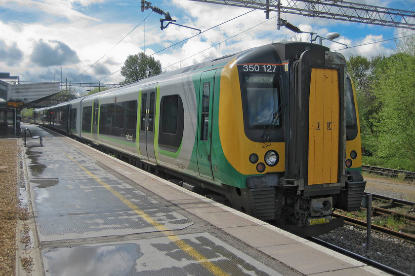 350127, LM 10.49 London Euston-Birmingham New Street (1W09), Northampton station 
 A typical day of April showers, witness the blue sky with dark rain clouds and the wet platform. 350127 waits at Northampton's platform three about to leave with the 10.49 London Euston to Birmingham New Street stopper service. I took this train as far as Canley, just north of Coventry. 
 Keywords: 350127 10.49 London Euston-Birmingham New Street 1W09 Northampton station London Midland Desiro