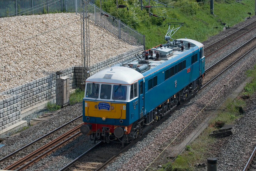 86259, 11.30 Acton Lane Reception Sidings-Rugby CS (0Z89, 4E), Ashton Road bridge 
 Having been involved in railtour duties the previous day, 86259 'Les Ross/Peter Pan' returns light engine to its base in Rugby's former carriage sidings. Having left West Coast railway's Acton Lane facility at 11.30 it is seen passing Ashton Road bridge just south of Roade running as 0Z49. 
 Keywords: 86259 11.30 Acton Lane Reception Sidings-Rugby CS 0Z89 Ashton Road bridge