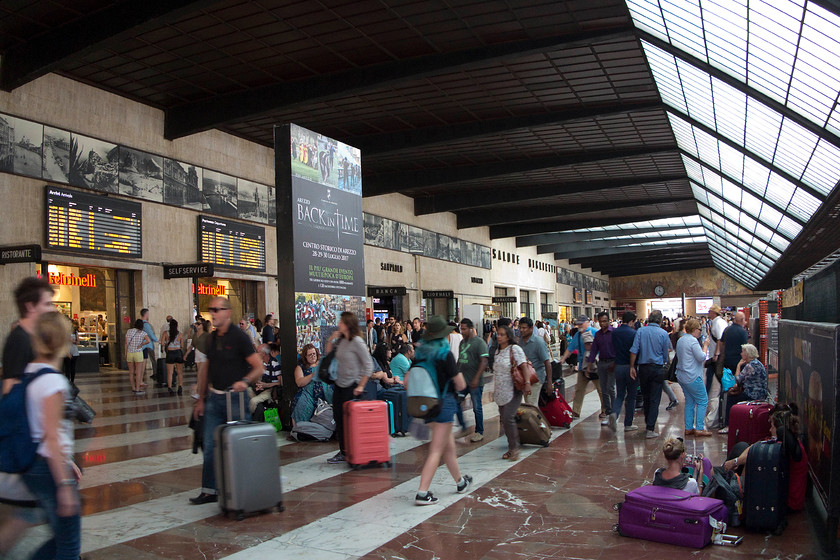 Concourse, Florence SMN station 
 The grand concourse of Florence SMN station, or in Italian 'Firenze Santa Maria Novella'.The vast glass skylights span the passenger concourse without any supporting columns, giving a feeling of openness and vast space. It is a busy station with 19 platforms. Unfortunately, during my visit there was evidence of a gate line being built the entire length of the station thus making access more difficult. 
 Keywords: Concourse Florence SMN station