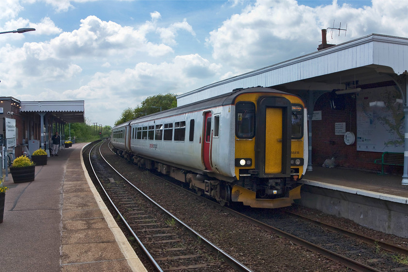 156418, LE 12.45 Norwich-Sheringham (2S18, 2L), Hoverton & Wroxham station 
 Unfortunately, the sun had gone in and the lighting is not great here are Hoverton and Wroxham station. 156418 leaves the station working the 2S18 12.45 Norwich to Sheringham operated by Greater Anglia. Notice the huge map of the Norfolk Broads on the wall of the station. Wroxham is often referred to as 'the capital of the Broads' and huge numbers of visitors arrive, many by train, during the summer months. 
 Keywords: 156418 2S18 Hoverton & Wroxham station