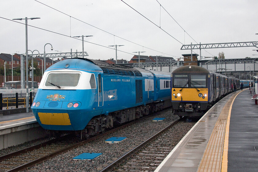 43055, outward leg of The Royal Highland Pullman, 07.39 London St. Pancras-Inverness (1Z90, RT) & 360119, EM 08.40 Corby-London St. Pancras (1H21, 2L), Wellingborough station 
 The first time that I have photographed two trains at Wellingborough's recently reinstated platforms three and four at the same time. To the left Midland Pullman HST 43055 sits at the ear of the outward 1Z90 Royal Highland Pullman charter; a three day extravaganza to Scotland including a run down the incredible line to Kyle of Lochalsh. The reflection of 360119's high-intensity lights shows strongly on the side of the HST as it waits to depart with the 08.40 Corby to St. Pancras local 'stopper'. 
 Keywords: 43055 The Royal Highland Pullman 07.39 London St. Pancras-Inverness 1Z90 360119 08.40 Corby-London St. Pancras 1H21 Wellingborough station Midland Pullman HST East Midlands Railway