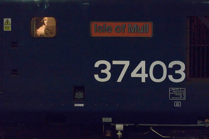 Nameplate, 37403, outward leg of 'The Wolf Hall Thunderer', 05.25 Derby-London St. Pancras (1Z40, 10L), Kettering station 
 The nameplate and large vinyl number of 37403 'Isle of Mull' is really struggling for illumination in this view as The Wolf Hall Thunderer charter it was hauling pauses at Kettering station. As D6607 37403 was delivered new to Landore. It was renumbered 37307 in 1974, and was selected in 1984 as one of twenty-five locomotives which were converted to work passenger trains in Scotland. Refurbishment for this role required the replacement of the main generator with an alternator and the provision of electric train heating. Thus modified as a class 37/4, the locomotive was renumbered 37403, and transferred to Glasgow Eastfield depot. From Eastfield, 37403 worked the West Highland and Oban lines, and was appropriately named 'Isle of Mull' in January 1986. In November 1988, the name was changed to 'Glendarroch', the fictional setting of the STV series Take the High Road. 
 Keywords: Nameplate 37403 The Wolf Hall Thunderer 05.25 Derby-London St. Pancras 1Z40 Kettering station Isle of Mull